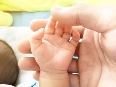 close up of Asian infant's hand with 1 month of age  in father's hand That represents innocence and...
