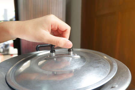 hand of woman is Catch the pot lid up to open.の写真素材