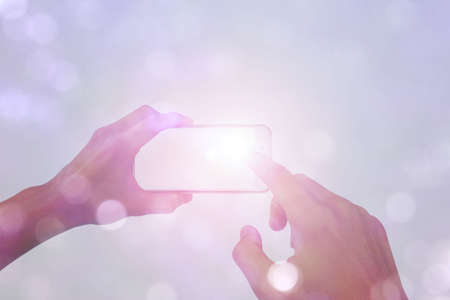 smartphone in hand with lens flare fantasy isolated on bokeh background