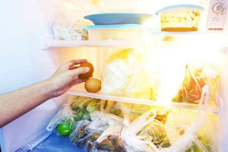 The hand of woman is picking up in the refrigerator To cook Such as eggs and vegetables.の写真素材