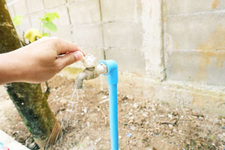 hand is open Outdoor faucet at outdoor with flow water