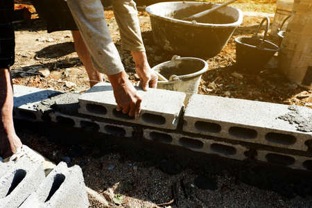 bricklayer is building the beam of home by brick with blocks.の写真素材