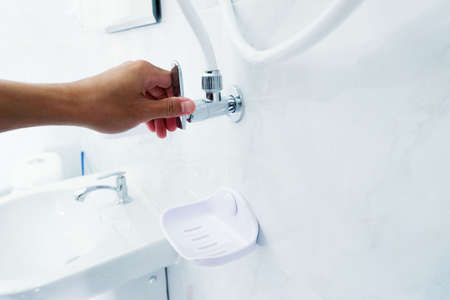Hand open faucet Of shower in bathroomの写真素材