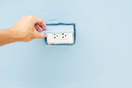 hand is open lid of Electrical outlet boxes with Installed in the wallの写真素材