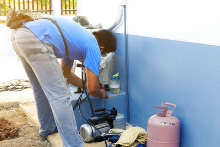 Air Conditioning Technician is Repairing air conditioner ,Because of leakage of air solution at the pipe jointのeditorial素材