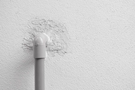 PVC pipes that protruded from the cement wall caused by the water system inside the house.の写真素材