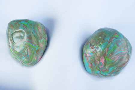 Clay balls on white paper that have been dried in the sun to soften.
