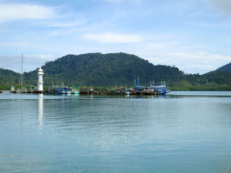 jetty with lighthouse and fishing boat at Koh Chang, Trad, Thailandの写真素材