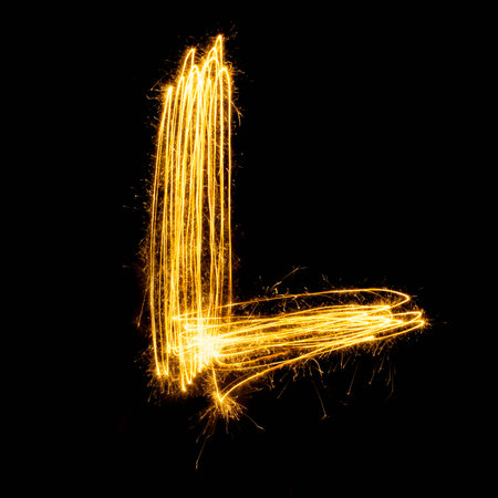 Sparkler firework light alphabet L with uppercase isolated on black background.の写真素材