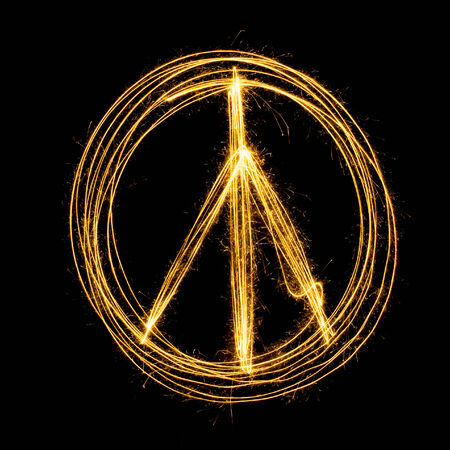 Sparkler firework light with peace sign isolated on black background.の写真素材