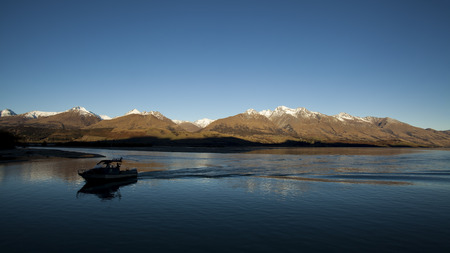 Boat on the beautyful lake and snow mountainの写真素材