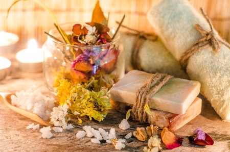 Two pieces of handmade spa soap with dry fragrance flower with blur soft yellow towel and aroma gel...