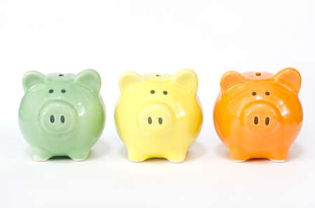 Closed up little gree, yellow, and orange piggy bank on white background, for saving and investment conceptの写真素材