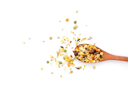 Mixed dry organic cereal and grain seeds in wooden spoon on white backgroundの写真素材