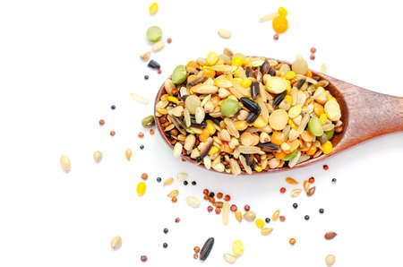Top view of variety dry organic cereal and grain seed pile on wooden spoon on white backgroundの写真素材