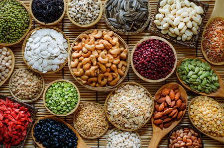 Variety kind of dry organic cereal and grain seeds in wooden and ceramic bowl in dark tone, for...