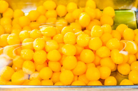 Group of Thai traditional style dessert known as Tong Yord or round egg yolk tart over by plastic...