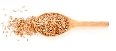Group of dry organic brown rice seed pile in wooden spoon on white backgroundの写真素材
