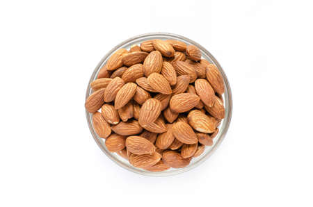 Top view of dry organic almond seed pile in glass bottle on white backgroundの写真素材