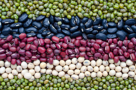 Dry organic cereal and grain seed stripe background consisted of mung bean, black and red bean and soybean seedの写真素材