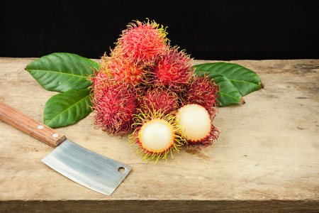 fresh fruit rambutan on wood background from thailand and a knife .の写真素材