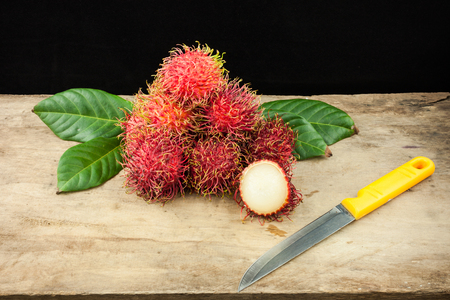 fresh fruit rambutan on wood background from thailand and a knife .の写真素材