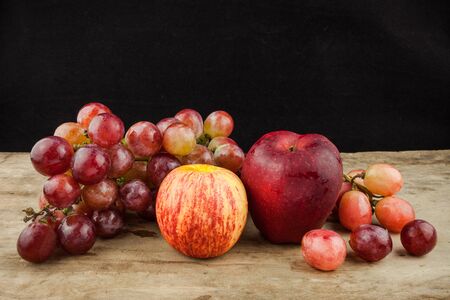 fresh fruit red grapes and red apple  on wood background .の写真素材