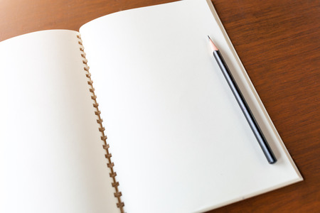 Blank note book with pencil on wooden table background concept and Idea for write your text here.の写真素材
