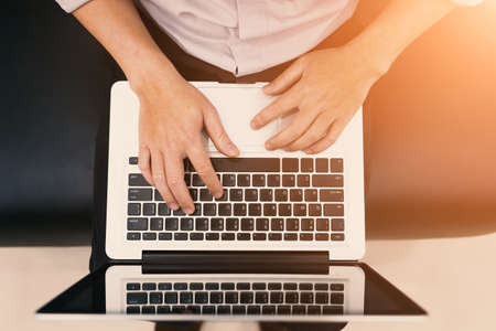 A man sit and using notebook .