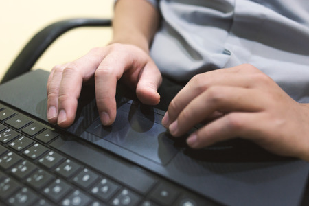 Adult man sit and typing laptop on your leg in home office .の写真素材
