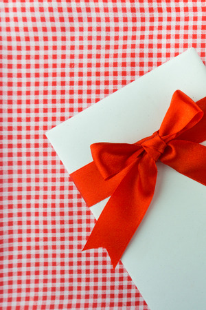 Valentines gift box with a red bow on red background. Image of Valentines day.の写真素材