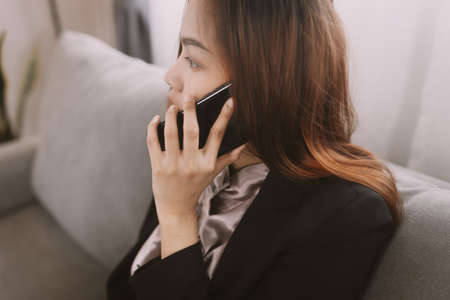 Woman work at the notebook sit on sofa at home concept for alternative office freelance.の写真素材