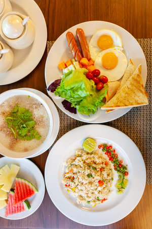 Full American Breakfast on dark, top view, banner. Sunny side fried eggs, roasted bacon, hash brown and toastsの写真素材
