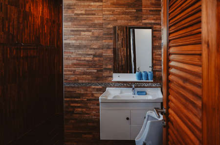 White sink and faucet in rustic loft bathroom. Dark Brown tone.