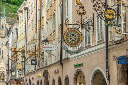 Salzburg, Austria - May 19,2019 : city skyline and wrought iron signs at Grain Lane street the famous shopping street of Salzburg Austriaのeditorial素材