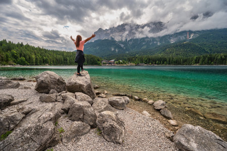 Zugspitze Peak top of Germany Alps mountain range and Eibsee Lake with woman tourist, Garmisch...