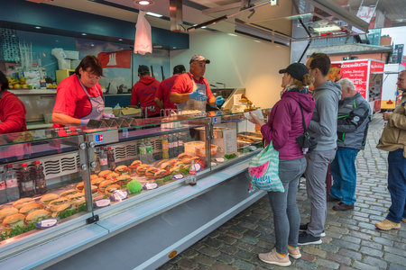 Hamburg, Germany - July 17, 2022: tourists buying fish burger at shop in famous Hamburg fish market (Fischmarkt)のeditorial素材