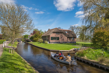 Giethoorn, Netherlands - May 4, 2023 : tourists navigating canal of Giethoorn village in boatsのeditorial素材
