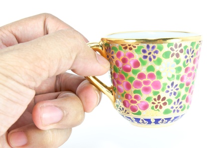 hand holding a golden thai tea cupの写真素材