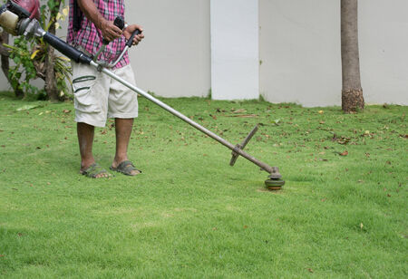 asia man mowing the grass