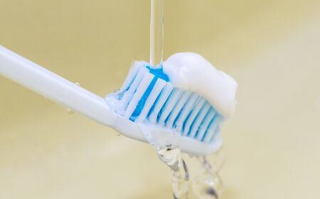 toothbrush with toothpaste and water close up shotの写真素材