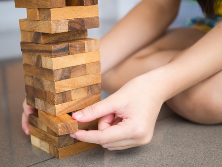 Closeup of asian kid's hand playing wood blocks stack gameの写真素材