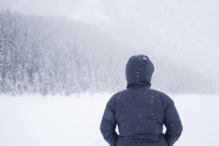 Young man standing on the lake in winter timeの写真素材