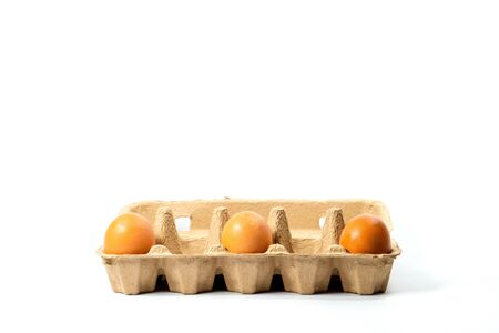 Three eggs in a paper panel spaced apart on a white backgroundの写真素材