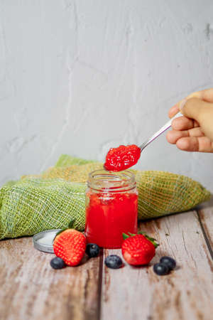 Strawberry jam and strawberry fruit placed on a wooden tableの写真素材