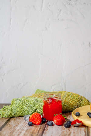 Strawberry jam and strawberry fruit placed on a wooden tableの写真素材