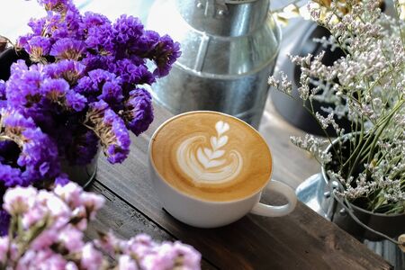 Coffee cup with latte art on the wood tableの写真素材