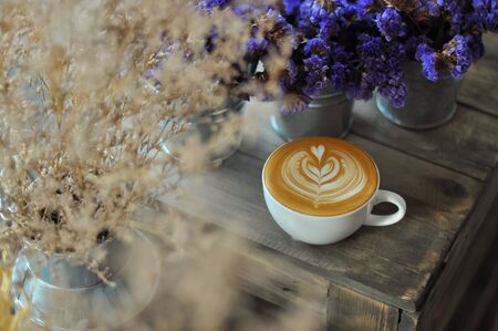 Coffee cup with latte art on the wood tableの写真素材