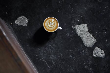 Coffee cup with latte art on the floorの写真素材