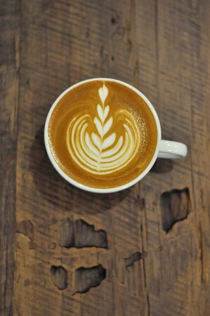 Coffee cup with latte art on the wood table.の写真素材
